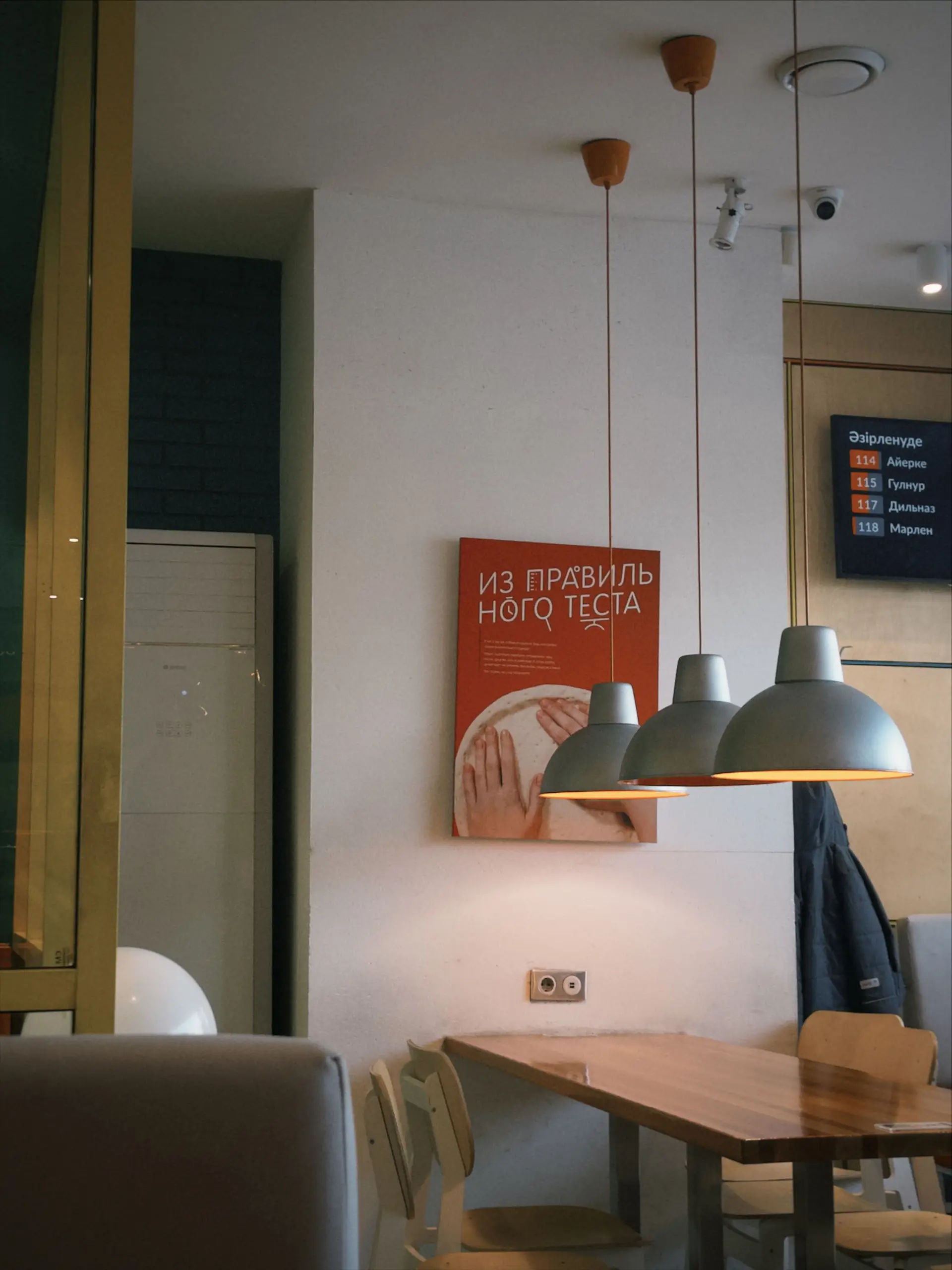 Minimalistiske pendellamper over spisebord i treverk